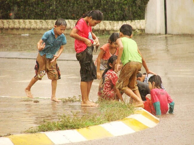 Children playing under the shower in Pakse, Laos